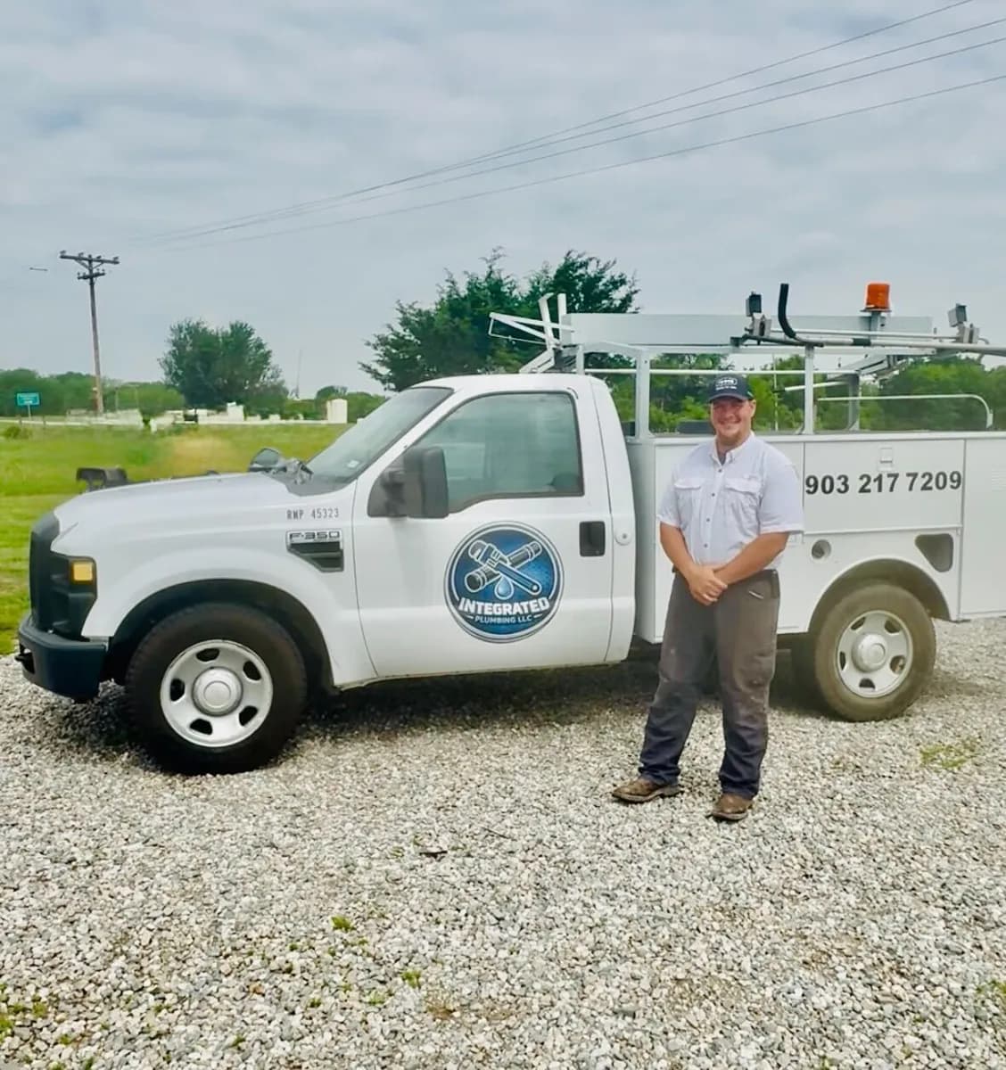Plumbing company owner standing beside his branded work truck