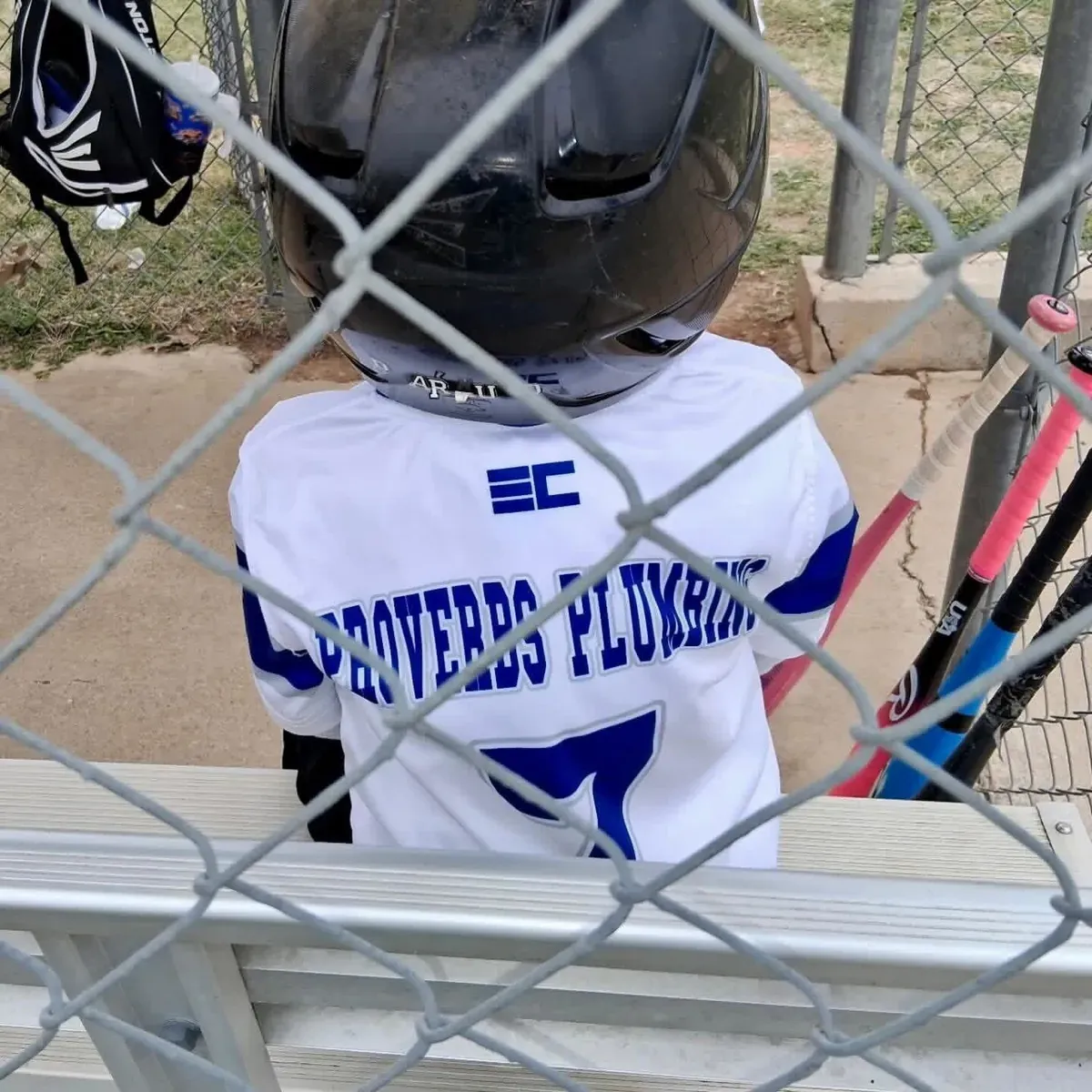 Youth baseball player wearing a plumbing company sponsored jersey